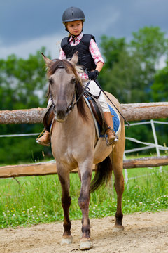 Horse riding - lovely girl is riding on a horse