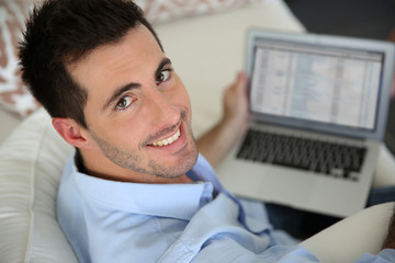 Fototapeta premium Upper view of young man using laptop computer at home