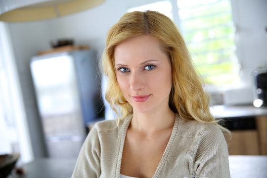 Beautiful blond woman standing in kitchen