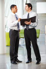 Fototapeta premium Two Businessmen Having Informal Meeting In Modern Office