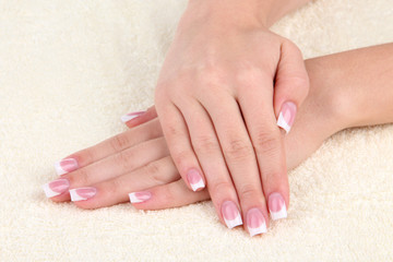 Fototapeta premium Woman hands with french manicure on towel