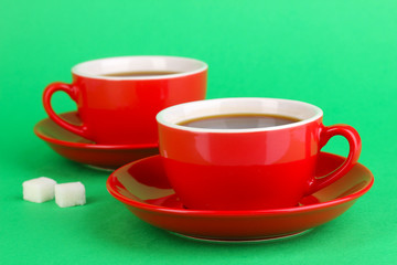 A red cups of strong coffee on green background