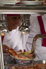 chef standing behind burger and pizza service station 