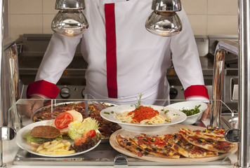 chef standing behind burger and pizza service station 