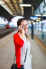 Fototapeta premium Pretty young woman at a train station
