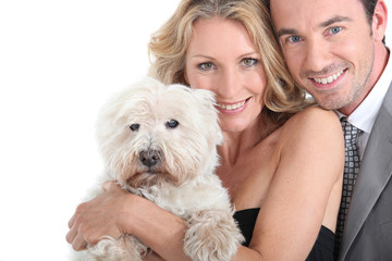 Couple cuddling dog.