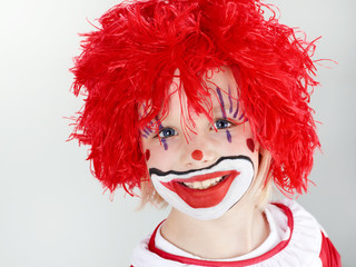 Beautiful child as a funny clown with red hair