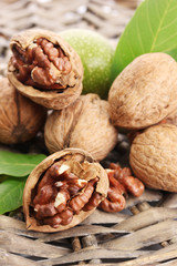 walnuts with green leaves, on  wicker background