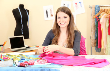 beautiful young dressmaker in workroom