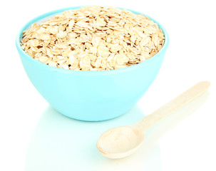Blue bowl full of oat flakes with wooden spoon isolated on
