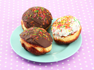 Tasty donuts on color plate on color background