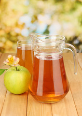 Full glass and jug of apple juice and apple