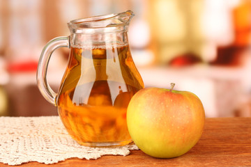 Full jug of apple juice and apple