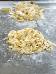 Uncooked fettuccine nest on tray