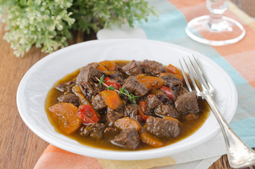 stew of beef with vegetables and prunes in a plate