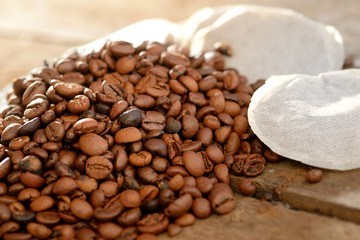 Fototapeta premium Kaffeepads mit Bohnen auf verwittertem Holz