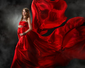 Pregnant woman in red flying dress