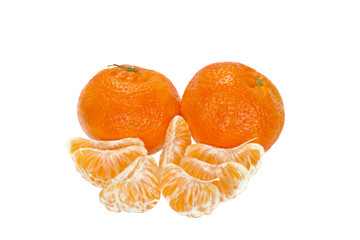 Two tangerines with slices in front of them isolated on white