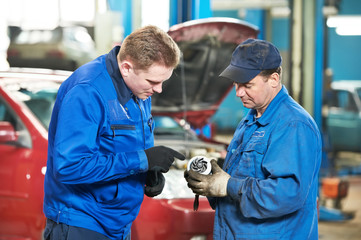 two car mechanic diagnosing auto engine problem