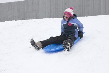Fototapeta na wymiar Girl rides on sled.