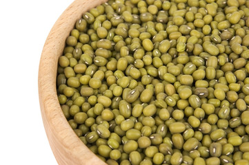 Raw mung beans in wooden bowl close-up over white background