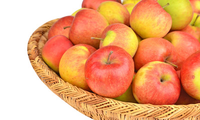 Red apple in a wattled basket, isolated on white background