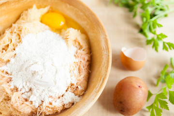 grated raw potatoes and flour in a bowl