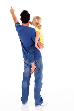 rear view of young father and daughter pointing