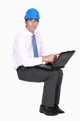 Engineer sitting in empty copyspace with a laptop