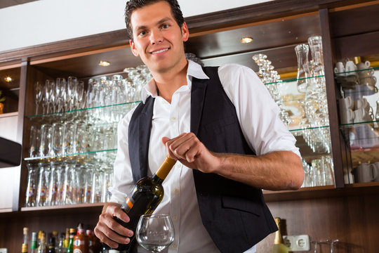 Barman Standing Behind Bar With Wine