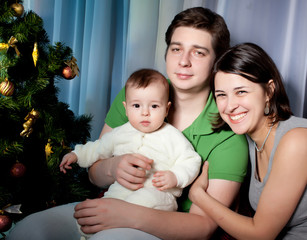 Happy family  against christmas tree