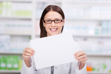 lächelnde apothekerin zeigt weißes schild