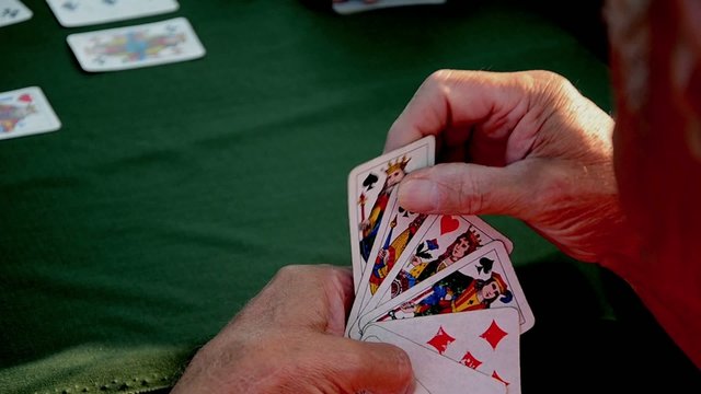 man waiting for his turn playing cards