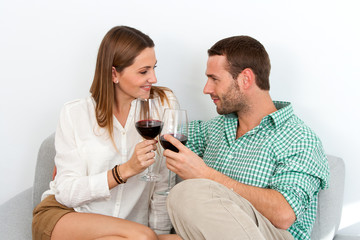 Couple enjoying a glass of red wine at home.