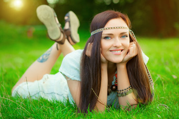 Smiling hippie girl on green grass