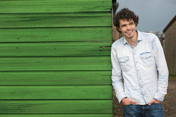 Casual Guy Leaning Against Green Wall