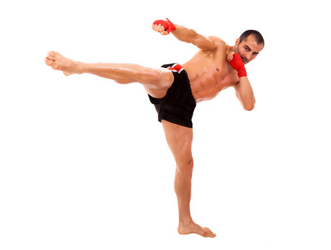 Young Boxer fighter making a kick over white background