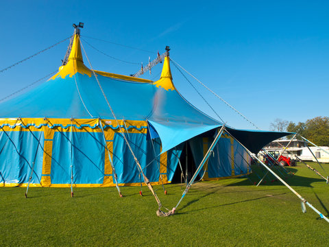 Main entrance of a blue and yellow big top circus tent