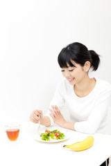 Obraz na płótnie Canvas a young asian woman eating salad