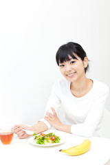 Obraz na płótnie Canvas a young asian woman eating salad