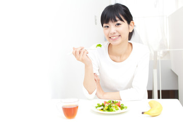 Obraz na płótnie Canvas młoda kobieta azjatyckie jedzenie sałatka
