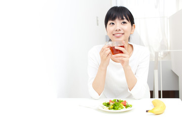 a young asian woman eating salad