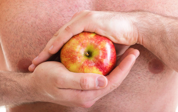 Muscle naked young man torso red apple in hands