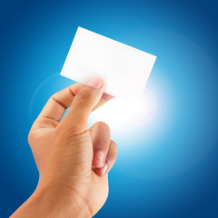 close up hand showing a blank card with blue sky background