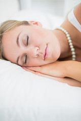 Fototapeta na wymiar Blisko śpi kobieta z naszyjnikiem pereł
