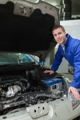 Happy mechanic repairing  car engine