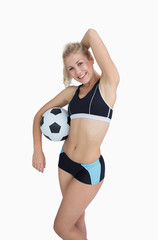 Sporty woman with football posing over white background