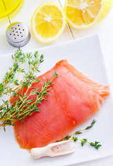 Raw salmon on the white plate with thyme and salt