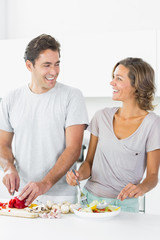 Obraz na płótnie Canvas Smiling couple making salad together