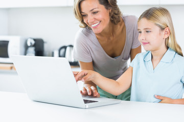 Fototapeta na wymiar Szczęśliwa matka i córka przy użyciu komputera przenośnego